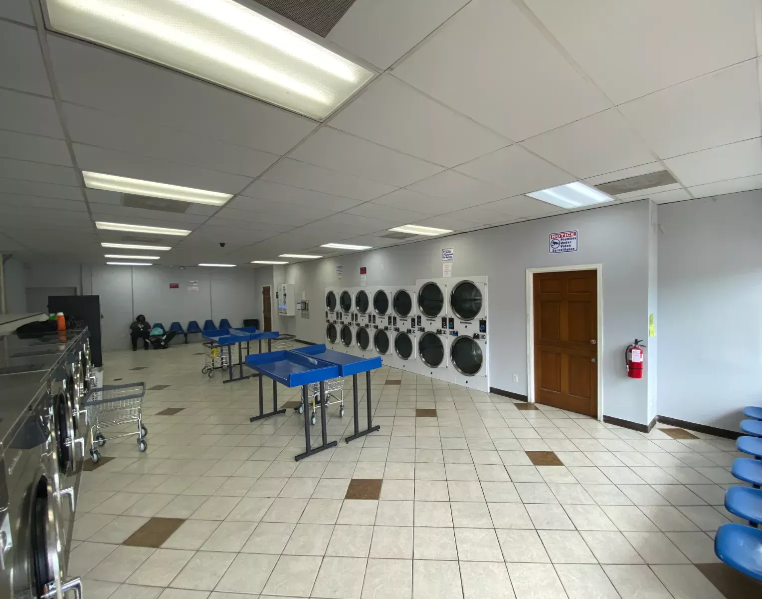 Bright, open floor with dryers and folding tables
