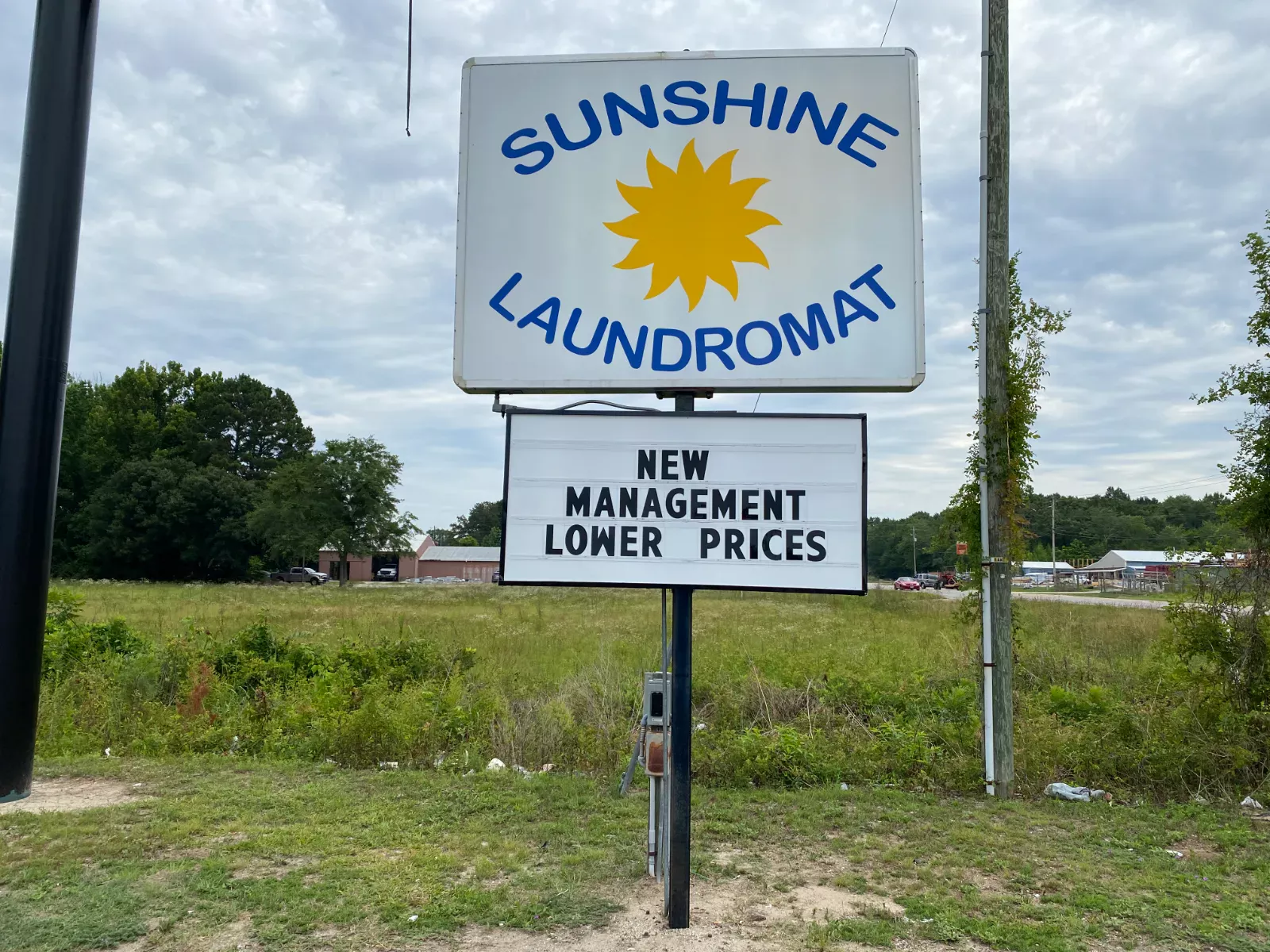 Sunshine Laundromat roadside sign: new management, lower prices